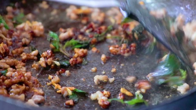 How to cooking thai food "Pad Kla Plaw" Thai women fried pork and ocimum sanctum.
