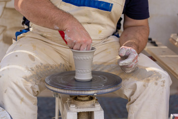 Potter works. Crockery creation process in pottery on potters' wheel.