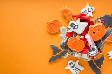 Halloween Jack o Lantern candy bowl with candy and halloween cookies Trick or Treat on orange background
