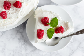 Meringue with whipped cream, raspberries.and mint