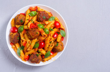 Italian penne pasta with meatballs and tomatoes