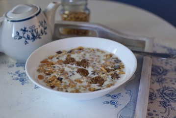 Bowl full of chocolate muesli with hearts and spoon, white and blue colors
