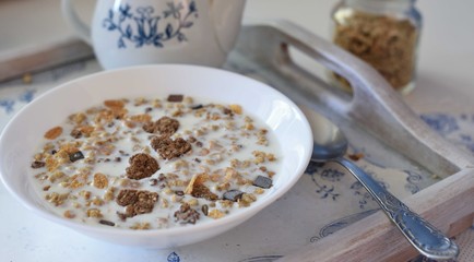 Bowl full of chocolate muesli with hearts and spoon, white and blue colors