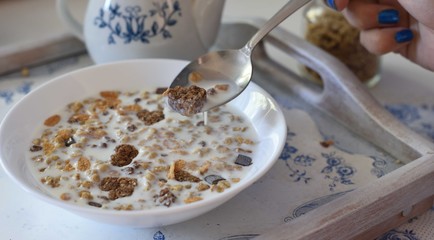 Bowl full of chocolate muesli with hearts and spoon, white and blue colors