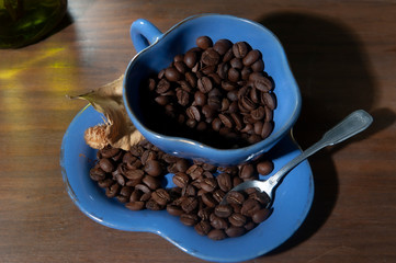 Blue cup with brazilian coffee beans. Brazilian coffee beans. Dark background. Seen from above.