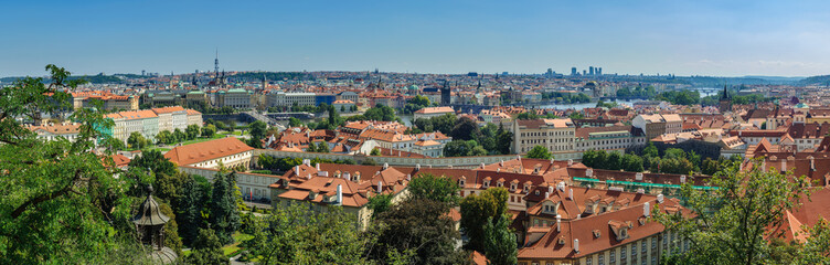 Fototapeta na wymiar summer panoramic view of the historical areas of Prague, the Vltava River with bridges from a hill from Prague Castle through the roofs of the old town at the foot of the castle