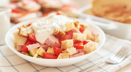fresh high-calorie salad with cheese, herbs, toast and ham