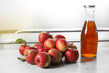 apple juice in glass bottle  and apples on Woden Provence table