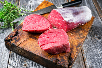 Rohes dry aged Rinderfilet Medaillon Steak natur angeboten als closeup auf einem alten rustikalen...