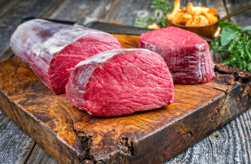 Rohes dry aged Rinderfilet Medaillon Steak natur angeboten als closeup mit Pfifferlingen auf einem...