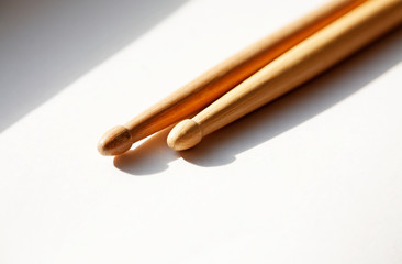 two drumsticks lie in the window sill with sunlight through windows