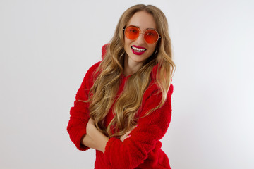 Closeup woman face with red lips, sunglasses hoodie isolated on white background. Fashionable girl in stylish outfit. Makeup, beauty concept. Winter autumn clothes. Shock excited female face. Close up