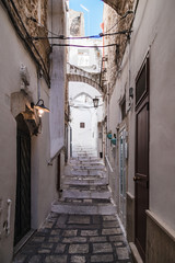 Obraz premium Ostuni, Italy - August 2019: Historic center of white city of Ostuni in Puglia, in a day of August