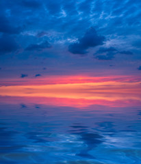 Naklejka na ściany i meble Sunset in the form of three colors of the sky: orange, purple, magenta over the sea.