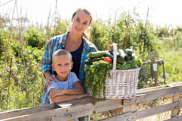 Obraz premium Woman and boy with gathered vegetables