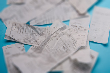 Pile of shopping receipts on blue background