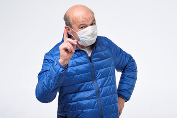 Senior man in medical mask giving advice