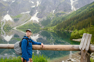 man relaxing on the lake and mountains sunny landscape