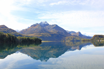 glassy lake with the reflection of a mountain