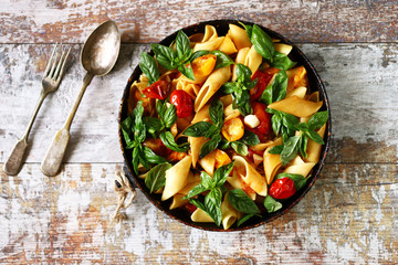 One pan vegan pasta. Appetizing pasta with tomatoes, basil and spices. Selective focus. Macro.