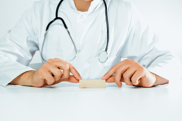 The doctor holds a empty block in his hand. Medical and pharmaceutical concept. A man wearing a white coat and stethoscope heals.