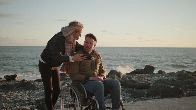 Male wheelchair user and his female friend are taking selfie by smartphone