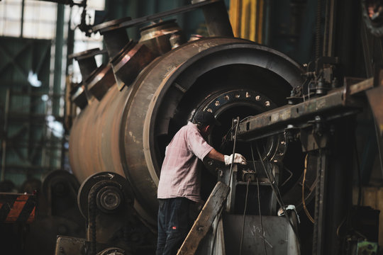 Senior worker in a dirty and old but still functioning metal works, old fashioned, factory