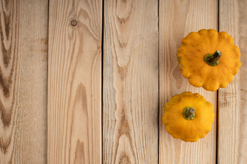 Fototapeta premium Still life of pumpkin and vegetables. Autumn yellow foliage on the wooden planks. Autumn background concept. Leaf fal. Copy space.