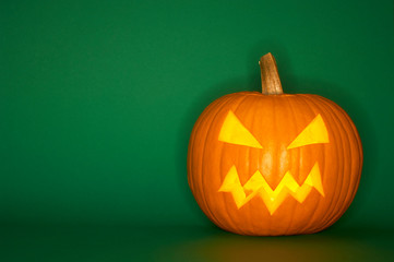 Halloween pumpkin head jack isolated on green background