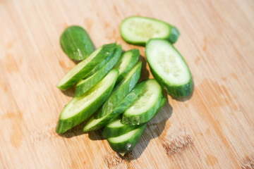 Sliced field cucumber, green mini cucumber on chopping board