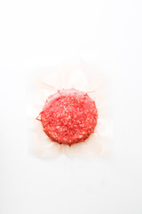 Sous vide hamburger ready to be cooked with a rooner, top view, flatlay on a white background