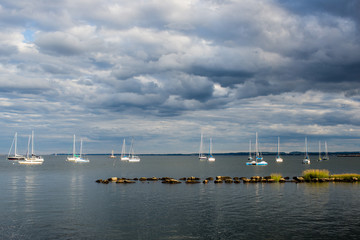 Fototapeta na wymiar Sailboats in bay summer dramatic sky