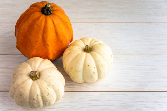 Small pumpkins on wooden background and copy space. Selective focus.Autumnal decorations.