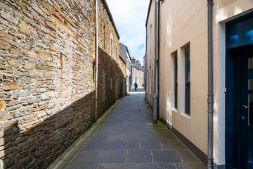 Narrow alley in a town centre on a sunny spring day. Kirkwall, Orkney Islands, Scotland, UK.