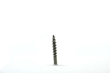 Isolated white wood screw element being drilled into paper.