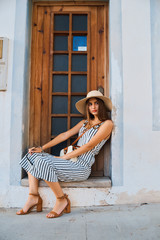 Fashion portrait of young stylish woman walking on the street.