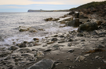 Fototapeta na wymiar Beach and rocks with waves rolling across rugged landscape