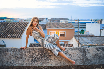 Young elegant barefoot woman posing on the street.