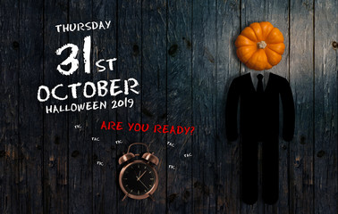 Date of Halloween 2019 with alarm clock on wooden background