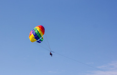 parachuting over the sea entertaining tourists at sea on vacation on the beach