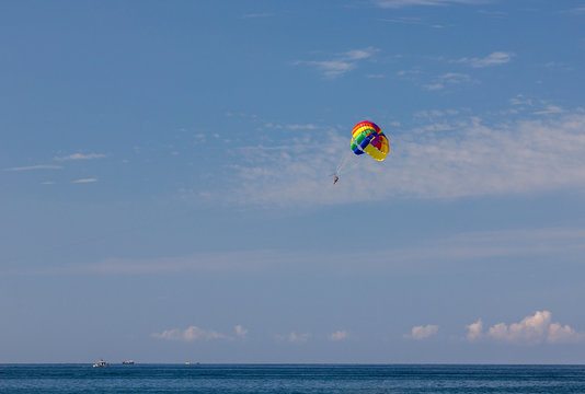 parachuting over the sea entertaining tourists at sea on vacation on the beach