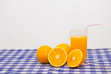 copo de suco e laranja cortada na mesa