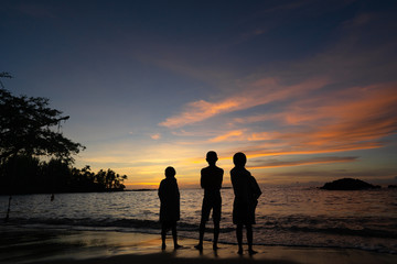 Children at beach watching sunset
