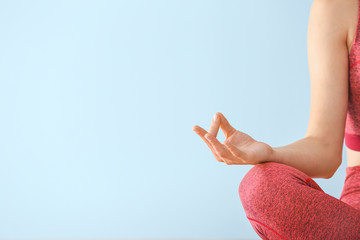 Young woman meditating on color background