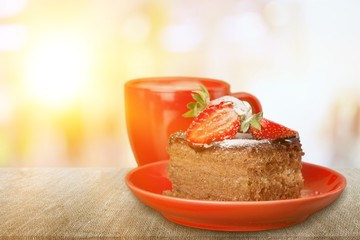 Slice of delicious chocolate cake on desk