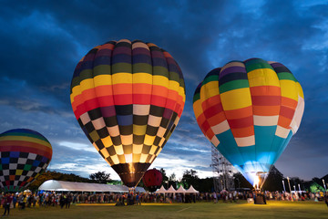 Obraz premium Hot air balloons preparing to rise in sunset or sunrice background.