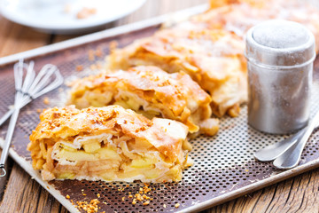 Frisch gebackener Apfelstrudel mit puderzucker auf einem backblech