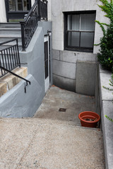 Old brownstone apartment building with upper and lower entryways, horizontal aspect