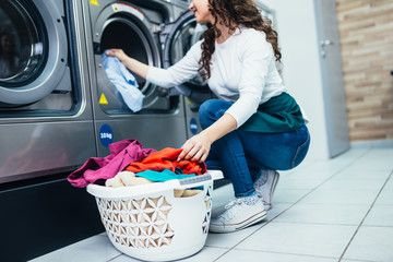 Beautiful female employee working at laundromat shop.