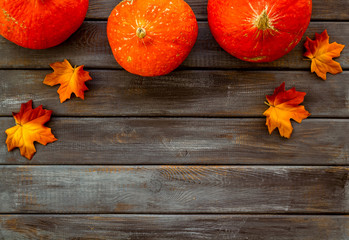 Autumn background with pumpkins and leaves on dark wooden table top view frame copy space